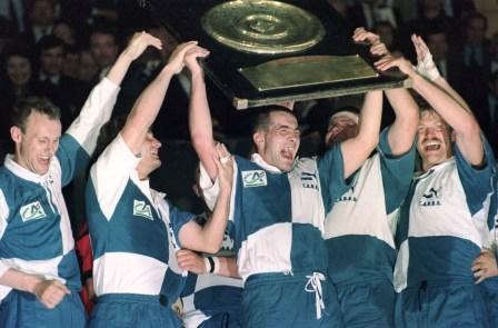 (ARCHIVES) - Photo prise le 01 juin 1991 au parc des Princes à Paris de Laurent Vergé brandissant le bouclier de Brennus entouré de (deGàD) Bernard Laporte, Sébastien Conchy et Régis Frentzel à l'issue de la finale du championnat de France de Rugby que Bègles-Bordeaux a remporté 19 à 10 face à Toulouse. Bordeaux-Bègles-Gironde (CABBG), qui a déposé le bilan et connaîtra dans quelques jours le nom du mandataire judiciaire chargé de régler son passif financier, a prouvé le 03 avril 2004 qu'il avait conservé son âme dans la tourmente en battant Toulon (15-11) lors de la 22e journée du championnat de France de Pro D2 de rugby. AFP PHOTO DANIEL JANIN